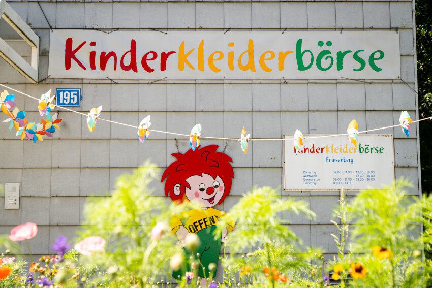 Detailaufnahme des Schildes der Kinderkleiderbörse mit Pumuckl darunter, aufgenommen in der Siedlung Verwaltungsgebäude (Etappe 21)