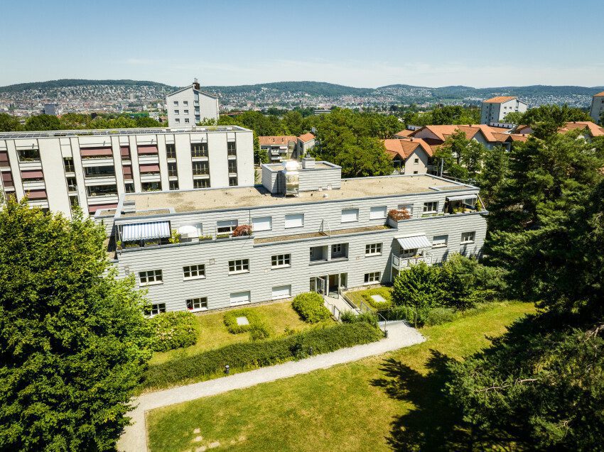 Luftaufnahme des Mehrfamilienhauses der Siedlung Verwaltungsgebäude (Etappe 21), davor Garten