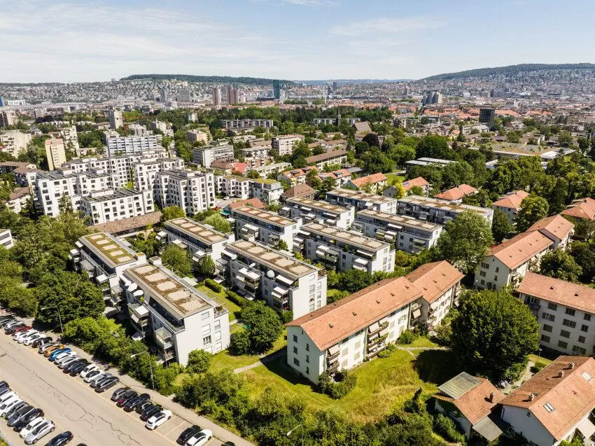 Luftaufnahme der Mehrfamilienhäuser in der FGZ-Siedlung Unterer Schweighof 1 (Etappe 11), dahinter sichtbar die Stadt Zürich