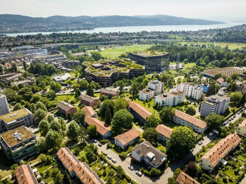 Luftaufnahme der Mehrfamilienhäuser in der Siedlung Hegianwandweg (Etappe 17), weit im Hintergrund sichtbar der Zürichsee